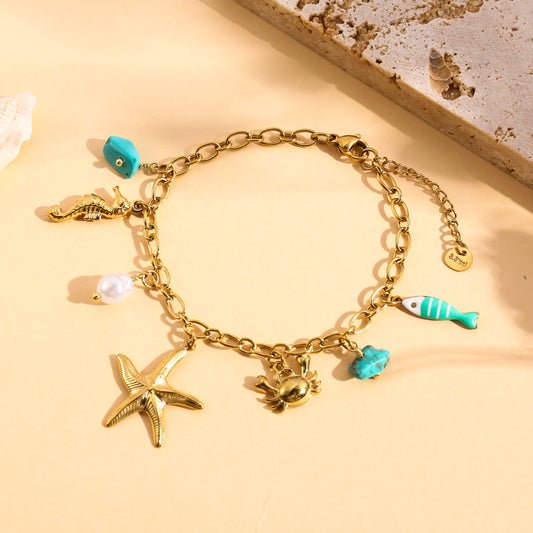 Bracelet doré à breloques étoile de mer et poisson turquoise