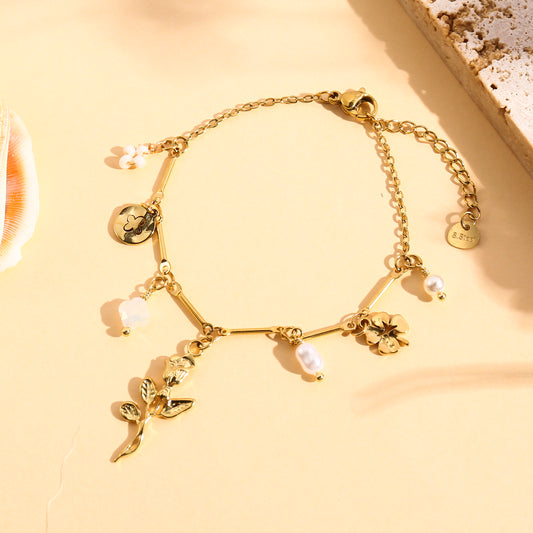 Bracelet doré à charms rose et perles