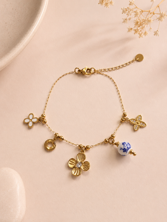 Bracelet doré à breloques fleurs et porcelaine bleue