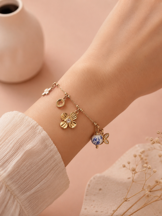 Bracelet doré à breloques fleurs et porcelaine bleue