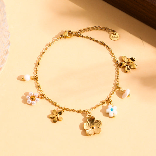 Bracelet doré à charms floraux et détails nacrés