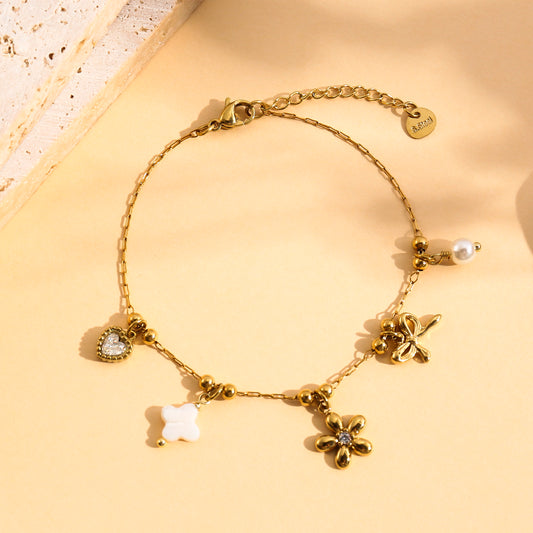 Bracelet doré à breloques fleur, nœud et cœur strassé