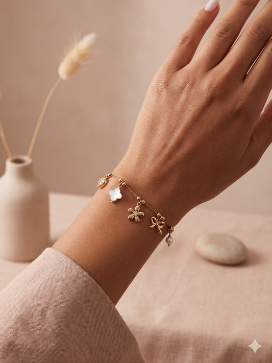 Bracelet doré à breloques fleur, nœud et cœur strassé