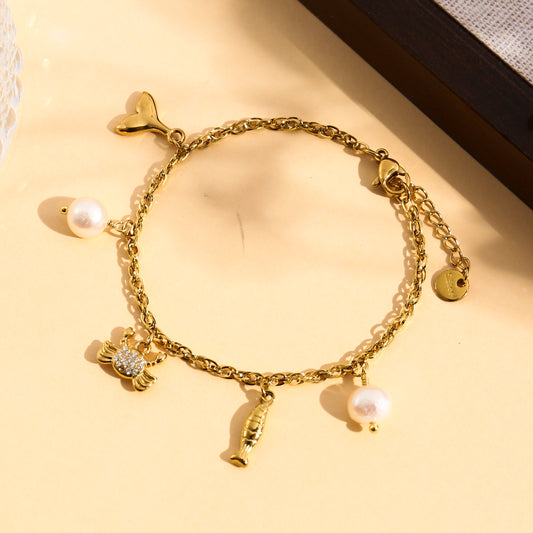 Bracelet doré à charms crabe strassé, poisson et perles