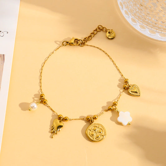 Bracelet doré à charms cœur, trèfle et fleur blanche