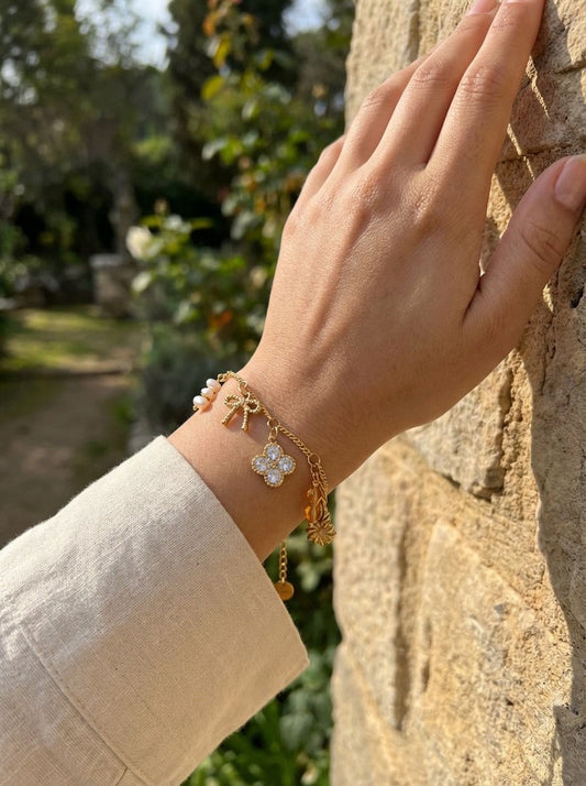 Bracelet doré à charms nœud, trèfle strassé et perles