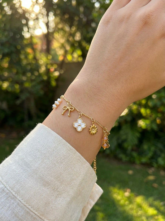 Bracelet doré à charms nœud, trèfle strassé et perles