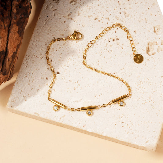 Bracelet doré à barres et strass pendants