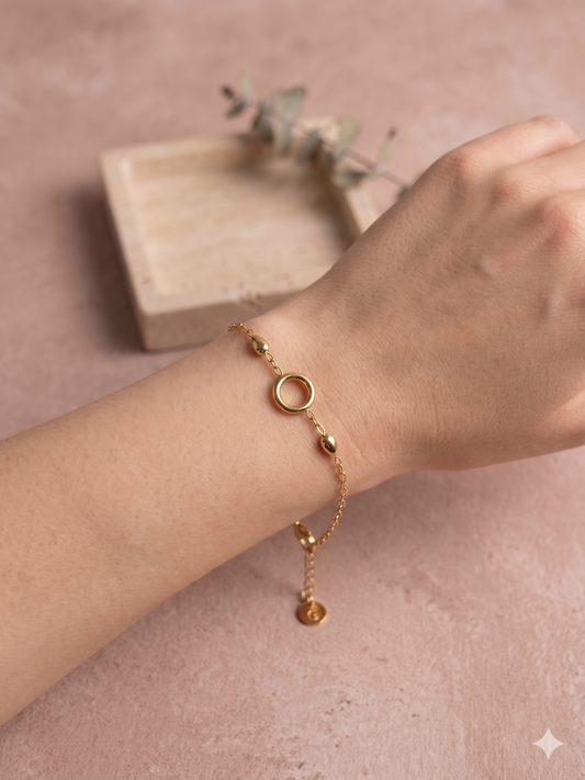 Bracelet doré à anneau central et gouttes polies