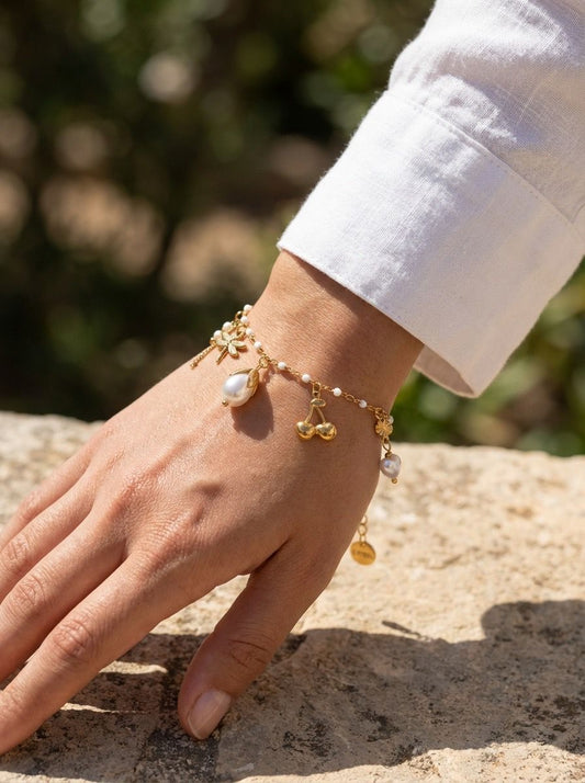 Bracelet doré émaillé blanche et breloques perles et cerise