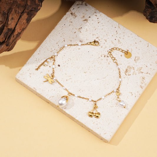 Bracelet doré émaillé blanche et breloques perles et cerise