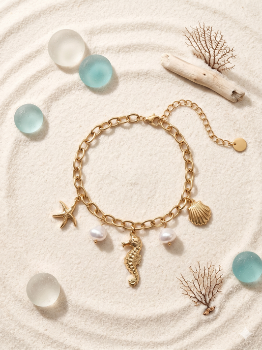 Bracelet doré à pendentifs marins et perles blanches