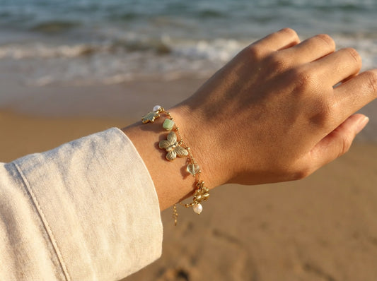 Bracelet doré à maillons ovales orné de charms marins et perles vertes