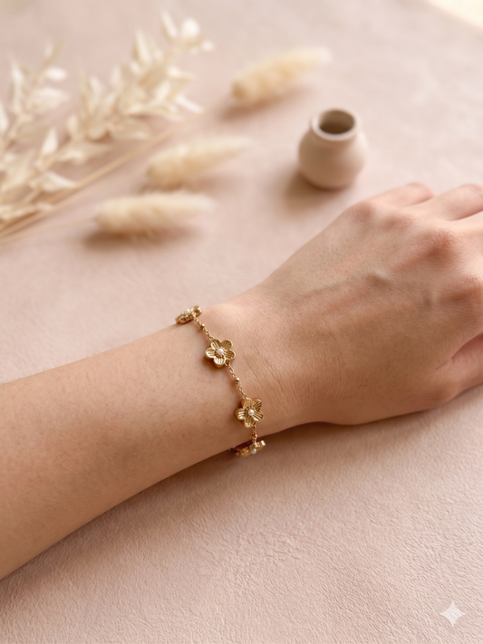 Bracelet doré orné de cinq fleurs avec perle centrale
