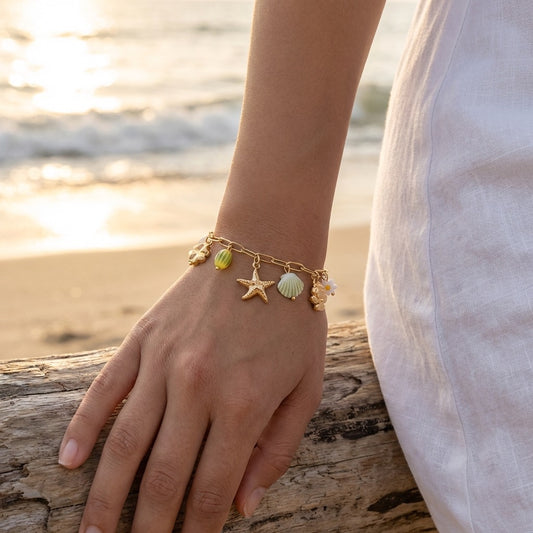 Bracelet doré à chaîne fine orné de papillon, perles et charms étoilés