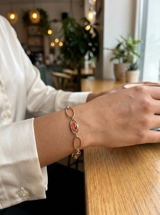 Bracelet doré à maillons ovales avec pierres rouges et roses