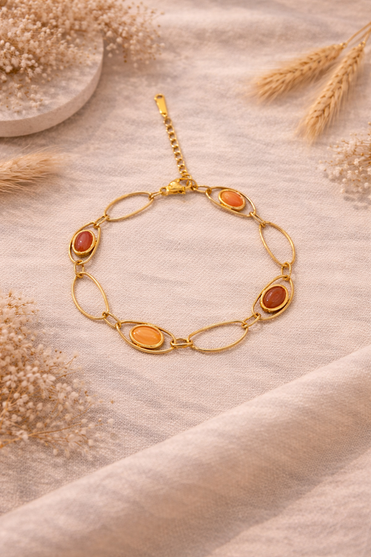 Bracelet doré à maillons ovales avec pierres rouges et roses