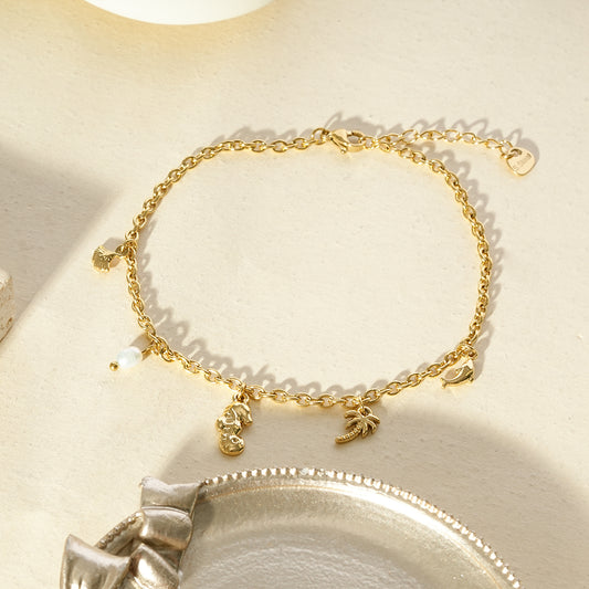 Chaîne de cheville dorée à charms marins et perle
