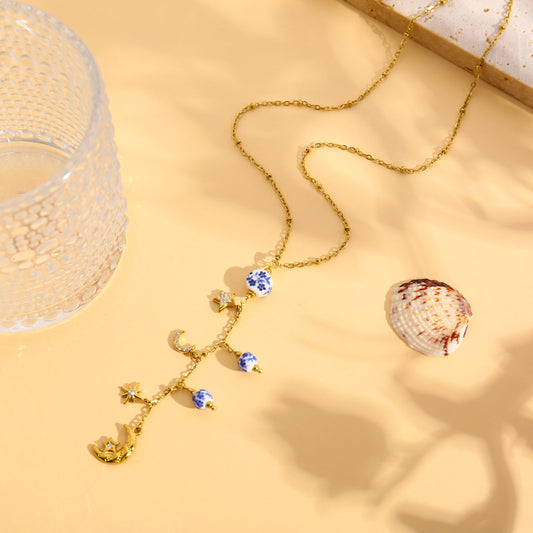 Collier doré avec breloques porcelaine bleu et constellation