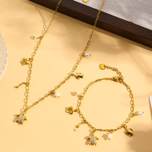 Collier doré à charms tortue strassée et perles blanches