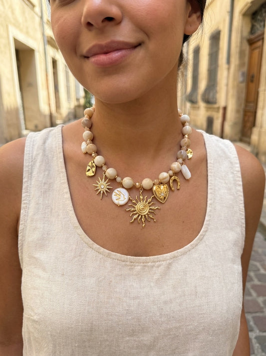 Collier doré à perles beiges et charms solaires rayonnants