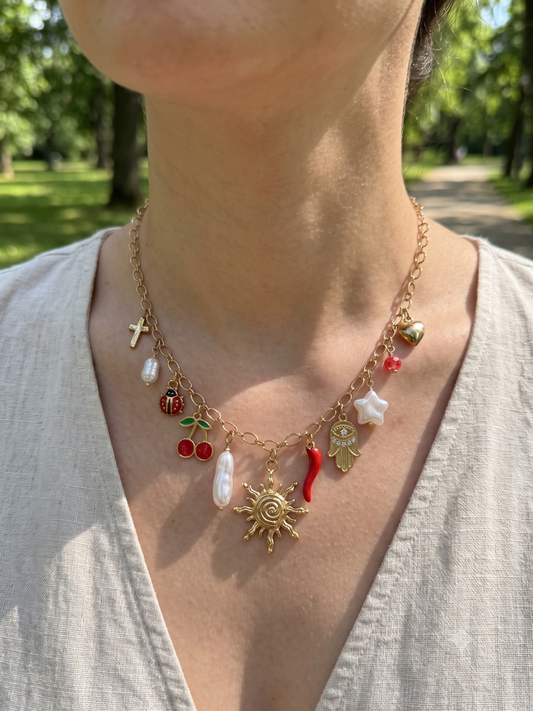 Collier doré à charms soleil, cerise, piment, main et étoile