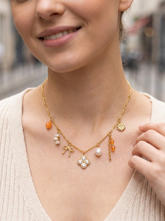 Collier doré à charms perles oranges, nœud et fleur strassée