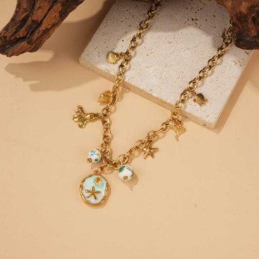 Collier doré charms plage et médaillon vert étoile de mer