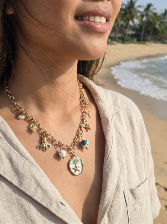 Collier doré charms plage et médaillon vert étoile de mer