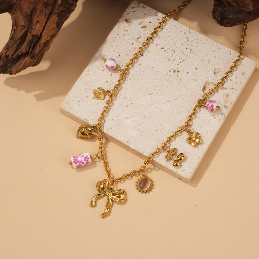 Collier doré pendentifs nœud texturé et porcelaines roses