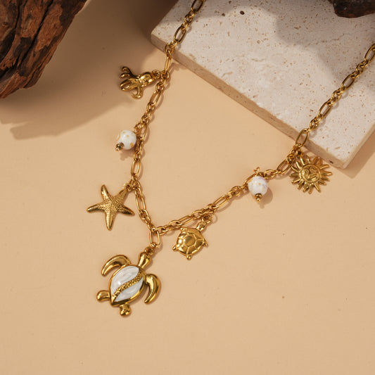 Collier doré à charms marins tortue nacrée et porcelaine beige