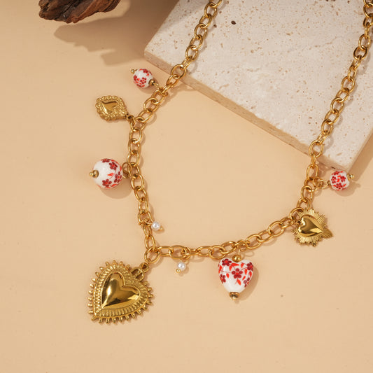 Collier doré à charms cœurs texturés et perles en porcelaine rouge