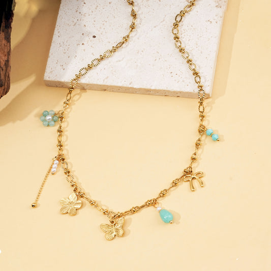 Collier doré fin à charms fleurs, papillon et perles bleues