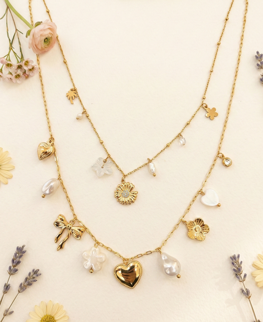 Collier doré double rang à charms floraux, cœur et perles
