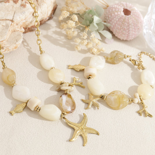 Collier doré perles en résine beige pendentifs marins