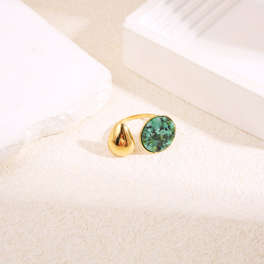 Bague dorée ouverture avant goutte effet miroir et cercle pierre verte