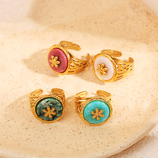 Bague dorée ajourée avec pierre ronde verte et motif fleur centrale