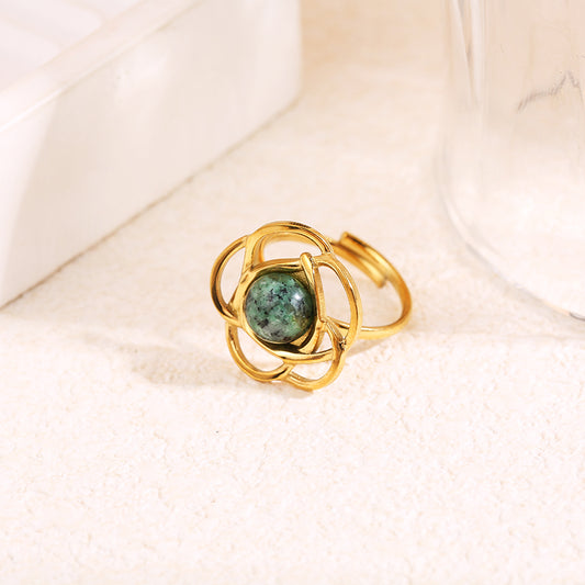 Bague dorée ajustable motif fleur ajourée avec pierre ronde verte au centre