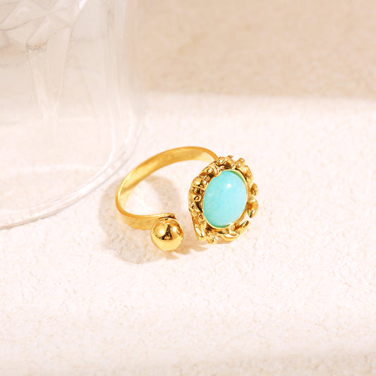 Bague dorée ouverture devant boule avec pierre bleue