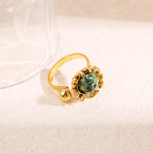 Bague dorée ouverte avec pierre ronde verte sertie