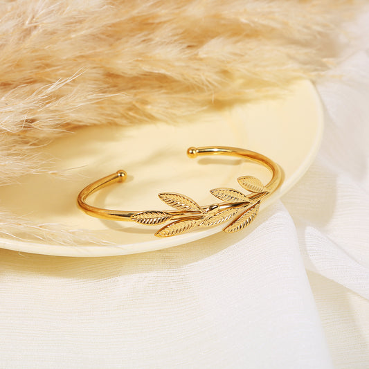 Bracelet jonc ouvert doré orné de feuilles sculptées avec billes dorées aux extrémités