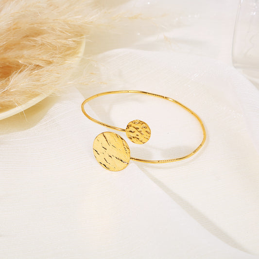 Bracelet jonc doré ajustable croisé à l'avant avec aux extrémités des cercles effet vague