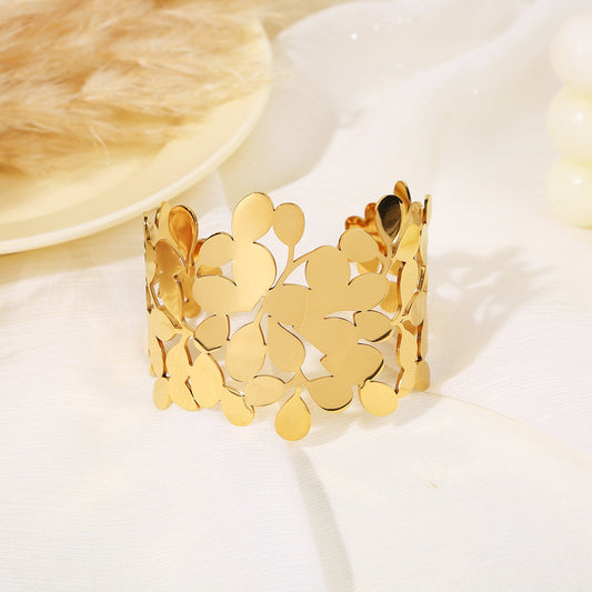 Bracelet manchette doré ajouré motif feuilles et gouttes stylisées en composition florale
