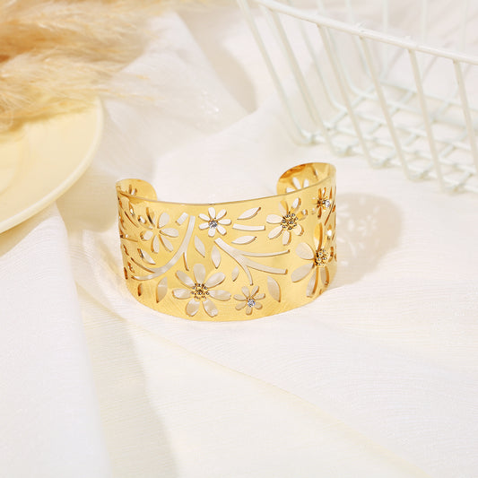 Bracelet manchette doré ajouré motif fleurs et feuilles, orné de strass au cœur des fleurs