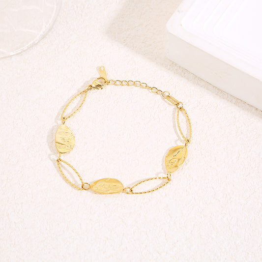Bracelet doré alternant maillons ovales texturés et médaillons gravés motif feuille