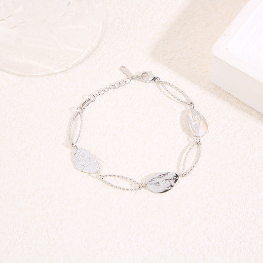 Bracelet argenté alternant maillons ovales texturés et médaillons gravés motif feuille