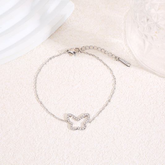 Bracelet chaîne fine argentée avec contour papillon central strassé aux angles arrondis