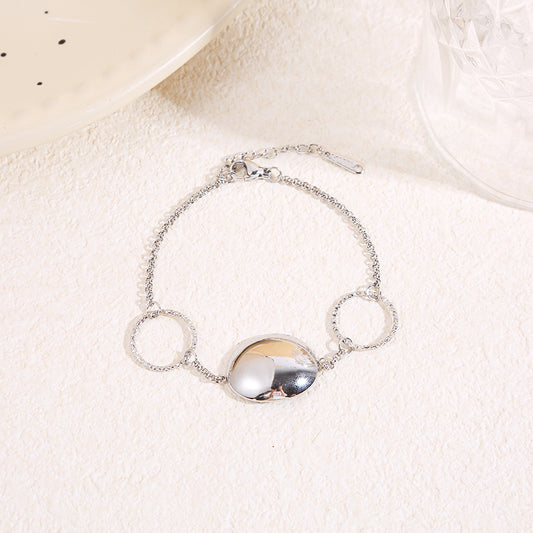 Bracelet chaîne fine avec deux anneaux texturés et pastille centrale bombée finition miroir