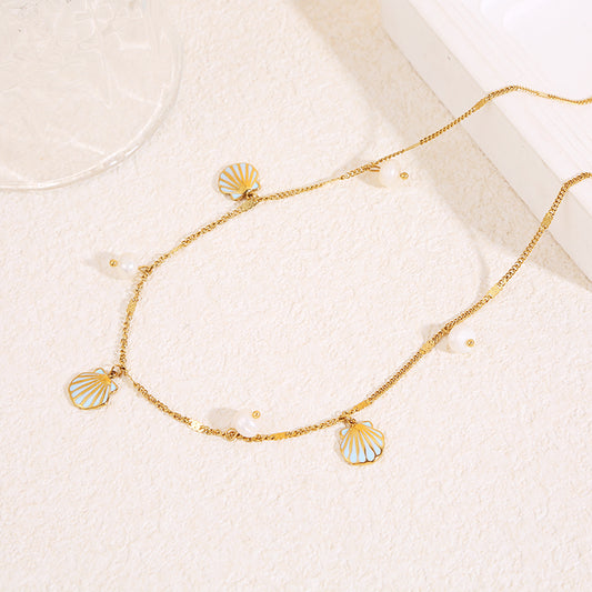Collier chaîne fine dorée avec pendentifs perles et coquillage bleue