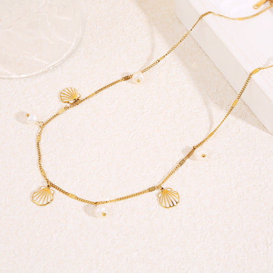 Collier chaîne fine dorée avec pendentifs perles et coquillage blanc